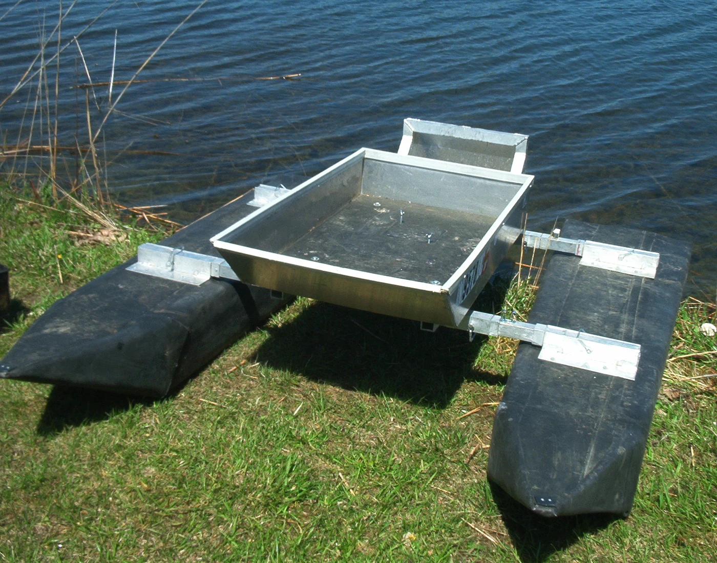 Actual assembled Tadpole Pontoon with aluminum platform, seat, trolling motor and twin black pontoons